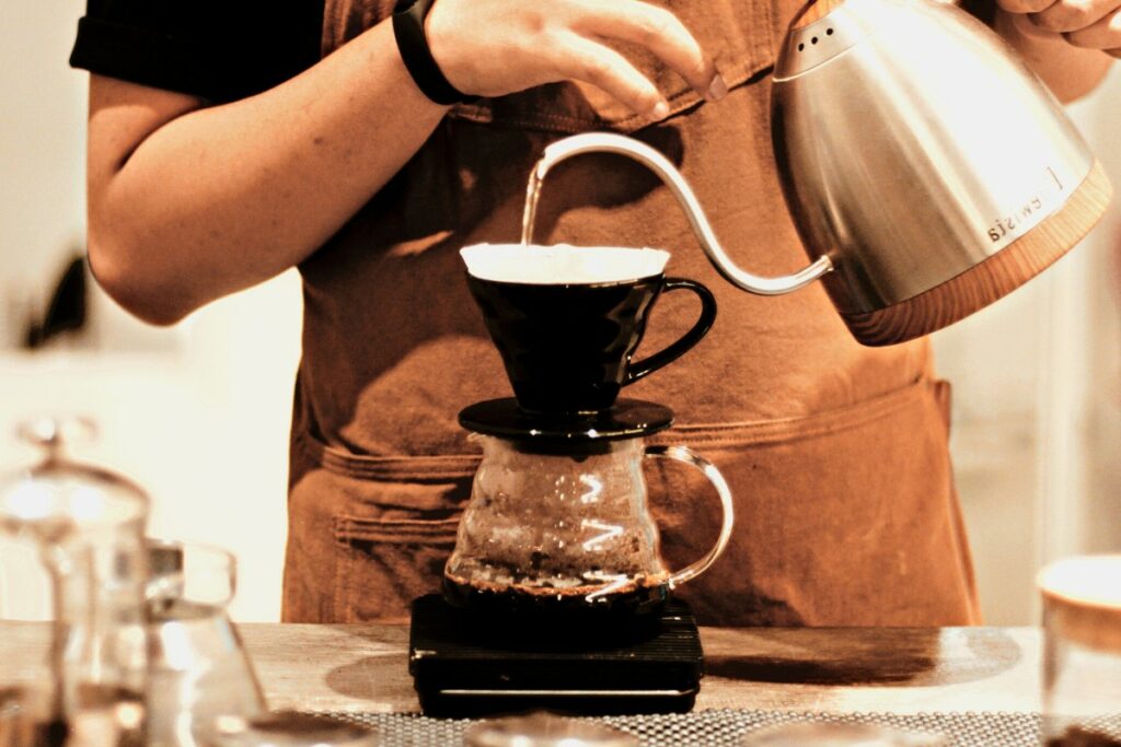 barista using v60 with decaf coffee beans